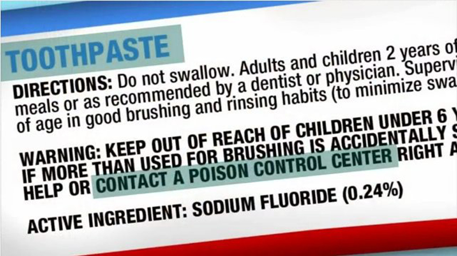 Close-up image of a fluoride toothpaste package displaying sodium fluoride (0.24%) as the active ingredient and a Poison Control warning if swallowed. Educational visual discussing fluoride toothpaste ingredients, oral health safety, consumer awareness, and toothpaste warning labels.